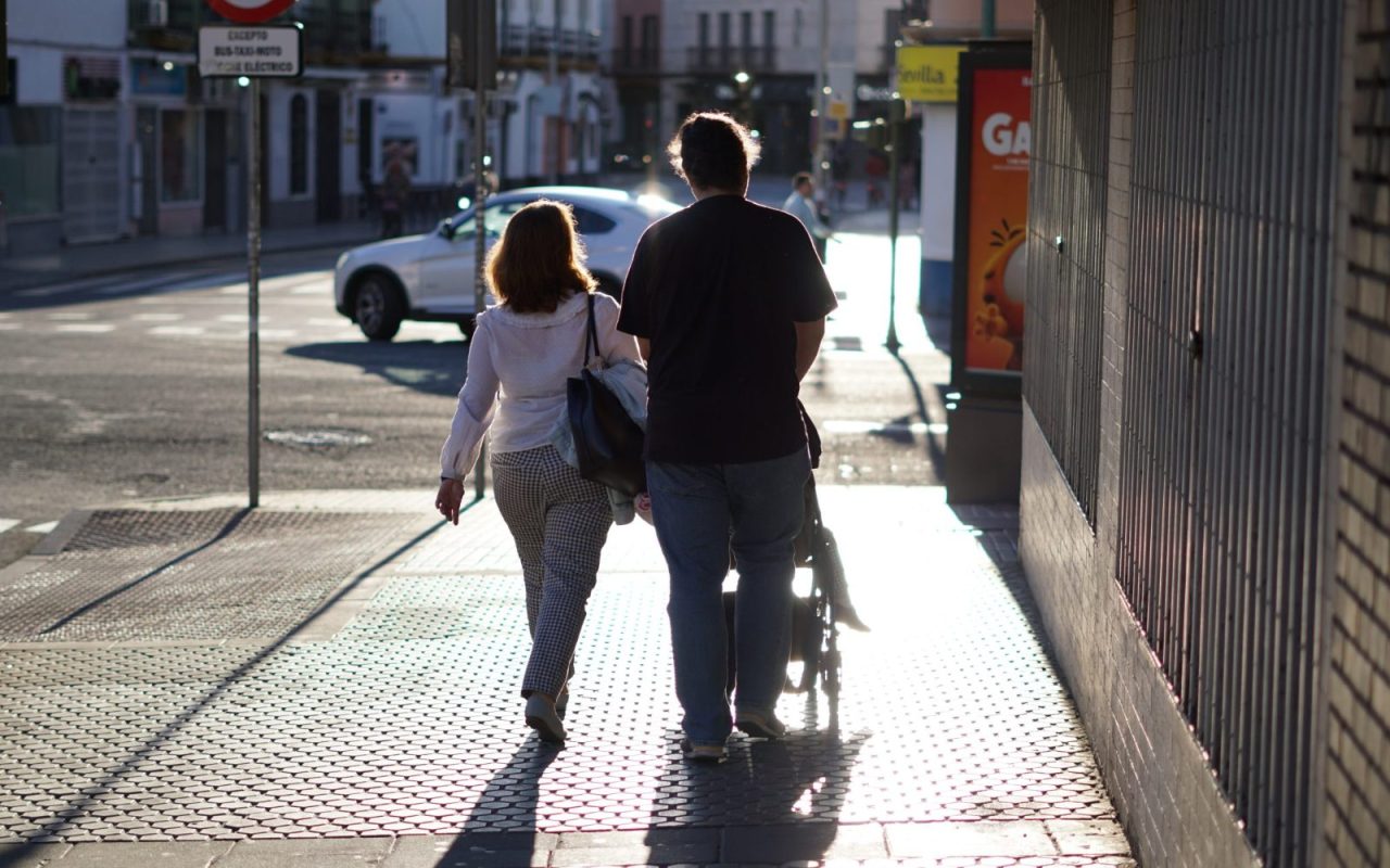 Couple pushing a stroller along a city street