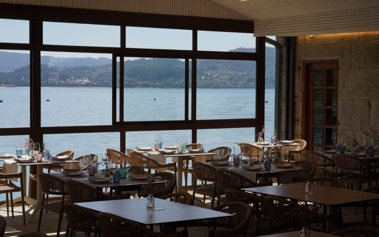 Restaurant dining room with tables by large windows